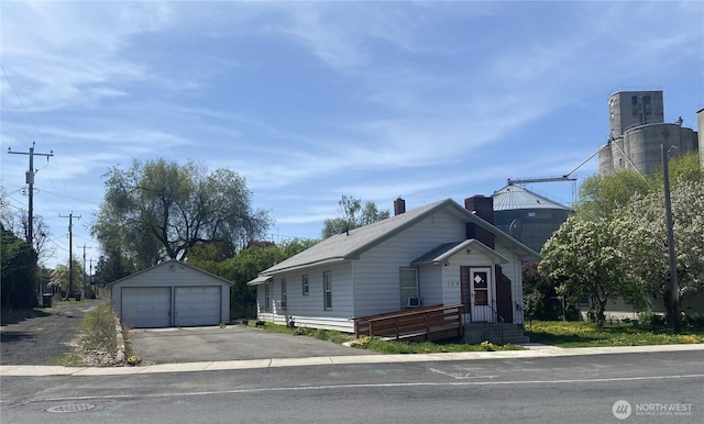 bungalow featuring an outdoor structure, a garage, and a chimney