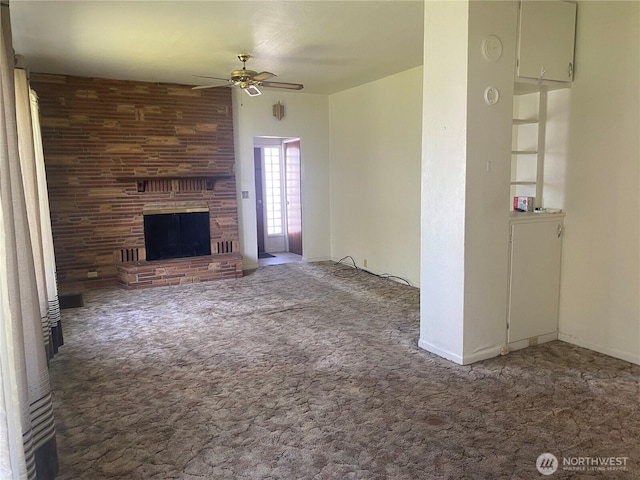 unfurnished living room featuring a large fireplace, a ceiling fan, and carpet floors