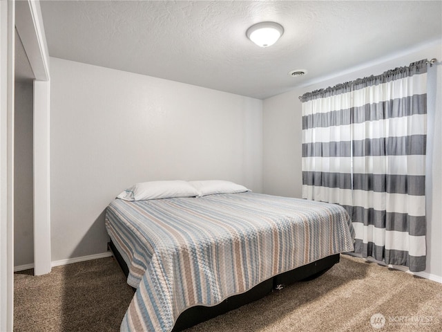 bedroom featuring baseboards, carpet, a textured ceiling, and visible vents