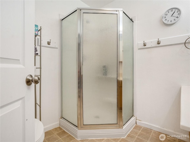 bathroom with baseboards and a stall shower