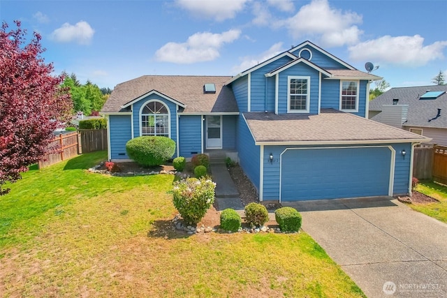 split level home with a front lawn, fence, roof with shingles, an attached garage, and driveway