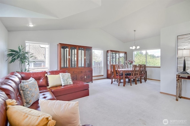 living room with plenty of natural light, lofted ceiling, a chandelier, and light carpet