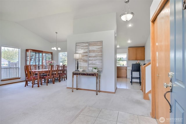 dining room with light tile patterned flooring, light carpet, a chandelier, baseboards, and vaulted ceiling