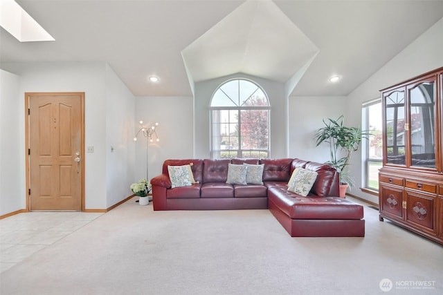 carpeted living area with baseboards, recessed lighting, and lofted ceiling with skylight