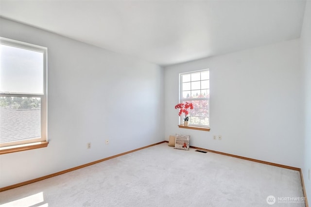 spare room with visible vents, carpet, and baseboards