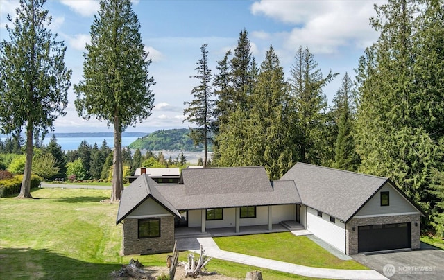 4306 Quaternary Rd, Clinton, WA 98236 - view of front facade with covered porch, brick siding, a water view, and a front yard