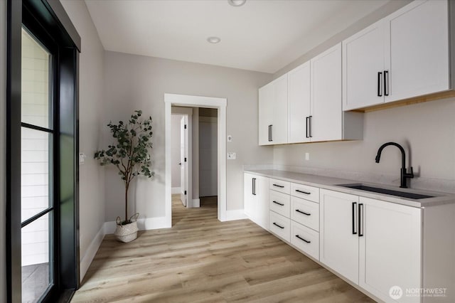4306 Quaternary Rd, Clinton, WA 98236 - kitchen featuring a sink, light countertops, light wood-style flooring, white cabinetry, and baseboards