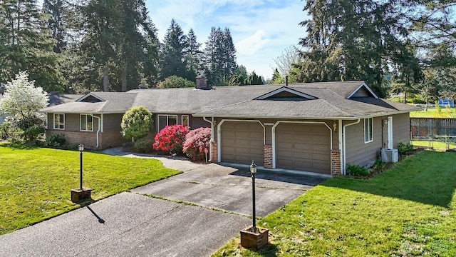 ranch-style house with a garage, fence, a front yard, and brick siding