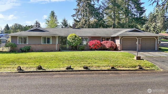 ranch-style home featuring a front lawn, a chimney, brick siding, an attached garage, and driveway