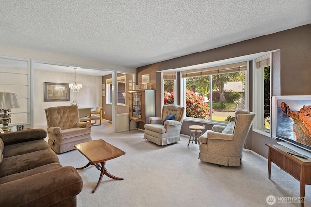 living area featuring an inviting chandelier, a textured ceiling, and carpet floors