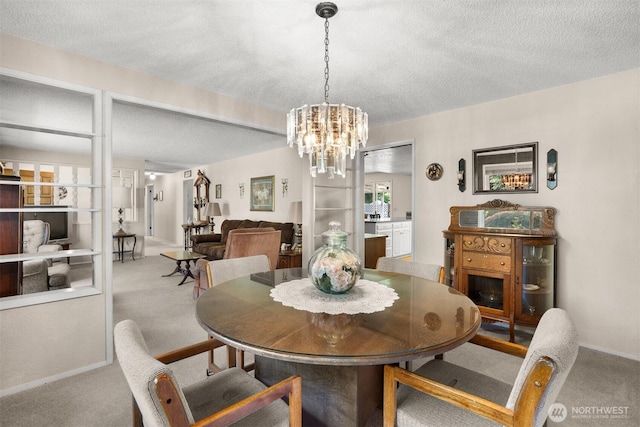 dining space with a textured ceiling and carpet