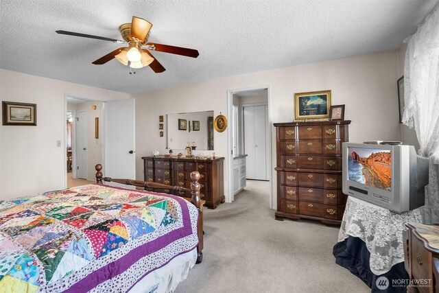 carpeted bedroom with a textured ceiling and ceiling fan