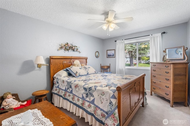bedroom with ceiling fan, a textured ceiling, and light colored carpet