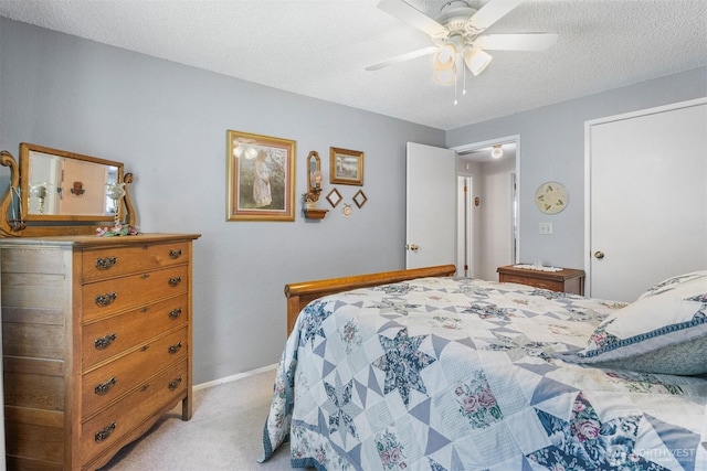 bedroom with baseboards, a ceiling fan, a textured ceiling, and light colored carpet