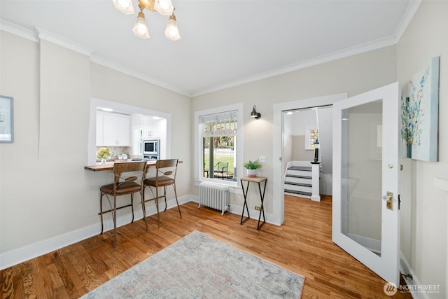 209 W 3rd St, Cle Elum, WA 98922 - dining space with crown molding, an inviting chandelier, light wood-style flooring, and radiator