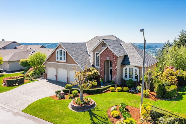 traditional home with driveway, a front yard, roof with shingles, brick siding, and an attached garage