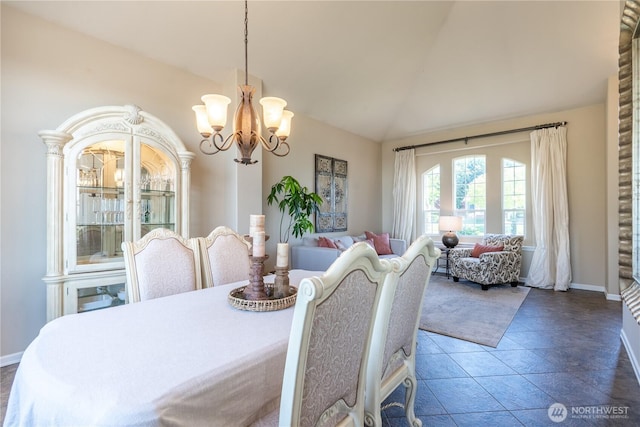 dining room featuring an inviting chandelier, baseboards, and vaulted ceiling