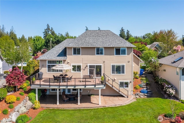 back of house featuring a lawn, a wooden deck, a patio, stairs, and outdoor dining space