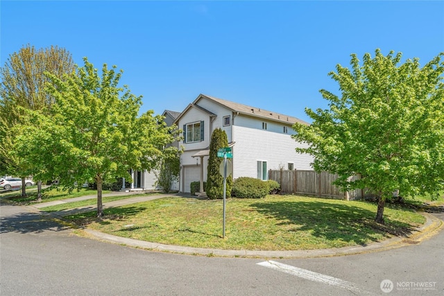 view of front of home featuring fence, an attached garage, concrete driveway, and a front lawn