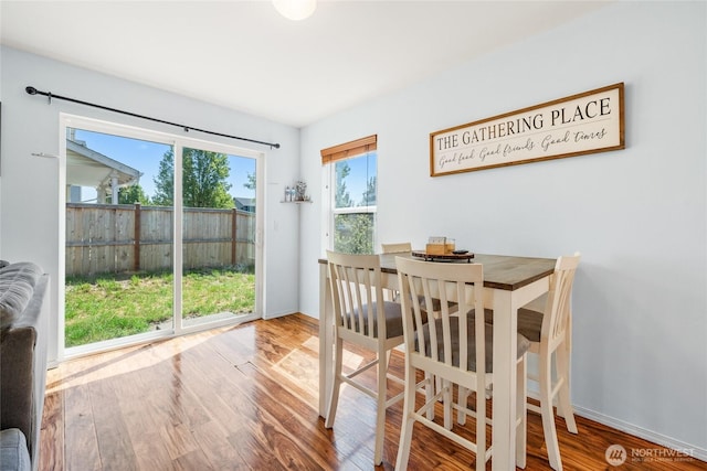 dining space featuring baseboards and wood finished floors