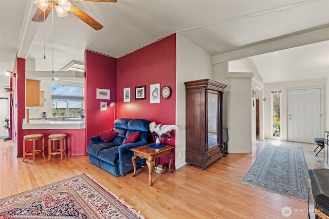 living area with light wood-type flooring, plenty of natural light, lofted ceiling, and ceiling fan