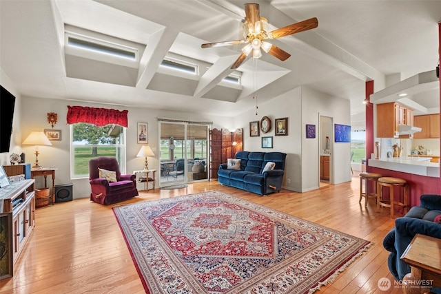 living room featuring a ceiling fan, coffered ceiling, beam ceiling, and light wood-style floors