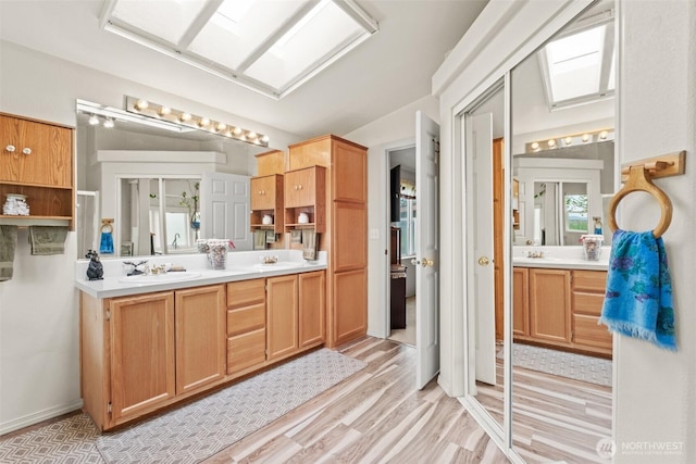 full bathroom featuring double vanity, a sink, and wood finished floors
