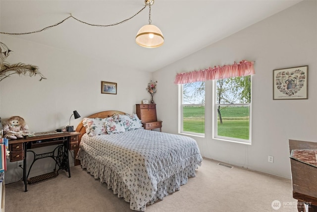 bedroom with visible vents, lofted ceiling, and light carpet