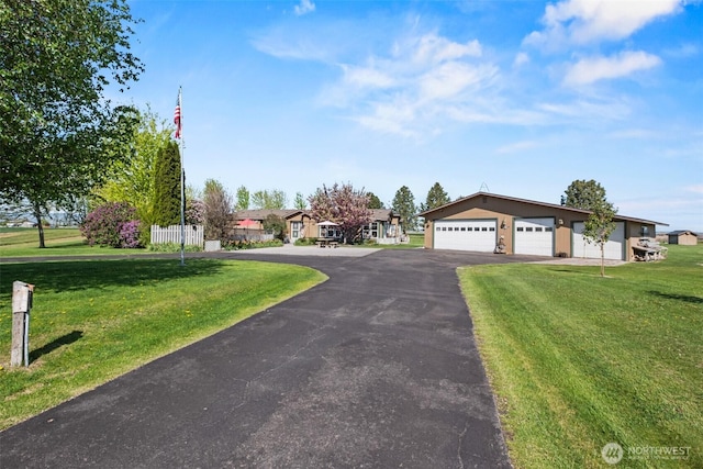 view of front of house featuring a garage, driveway, and a front lawn