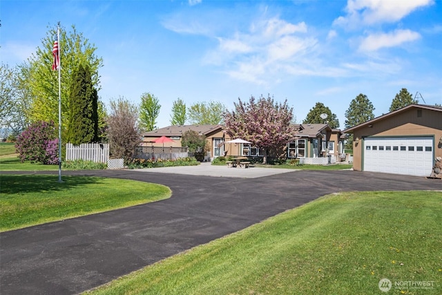 view of front of house featuring fence, a front yard, and a garage