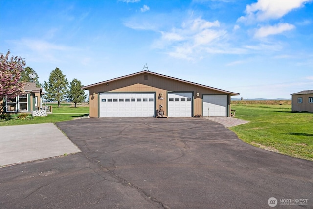 view of front of house with an outdoor structure, a front yard, and a garage