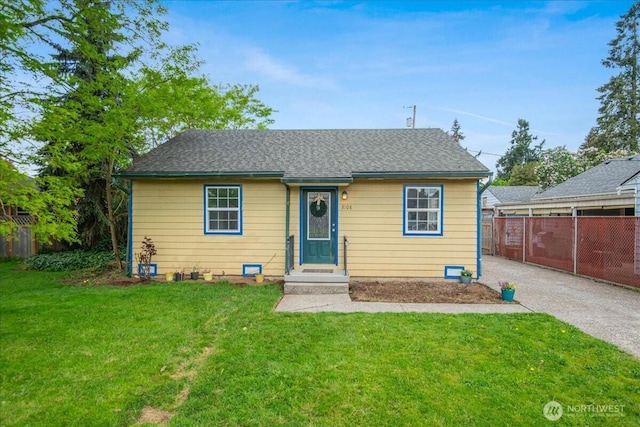 bungalow with a front lawn and fence