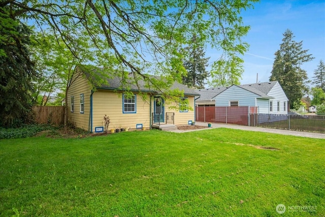 view of front of house featuring a shingled roof, fence private yard, and a front lawn