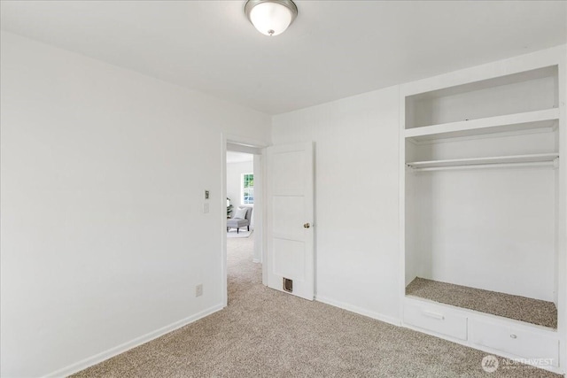 unfurnished bedroom featuring carpet flooring, baseboards, and a closet