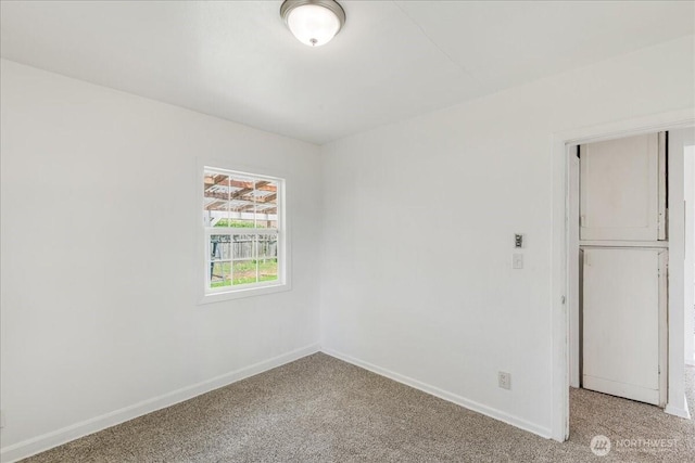 empty room featuring light colored carpet and baseboards
