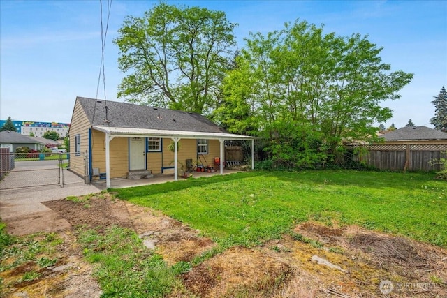 rear view of property with a lawn, a fenced backyard, a gate, and a patio area