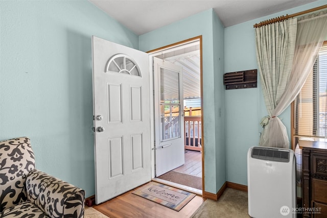 carpeted entrance foyer with baseboards and a wealth of natural light