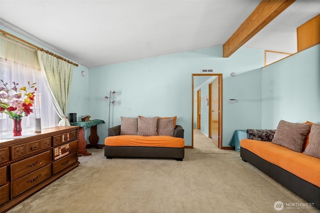 sitting room with visible vents, lofted ceiling with beams, and carpet