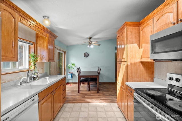kitchen with a sink, light floors, appliances with stainless steel finishes, and light countertops