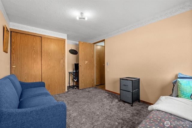 carpeted bedroom featuring a textured ceiling, baseboards, and a closet