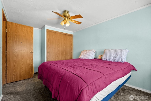 carpeted bedroom with baseboards, ornamental molding, a closet, and ceiling fan