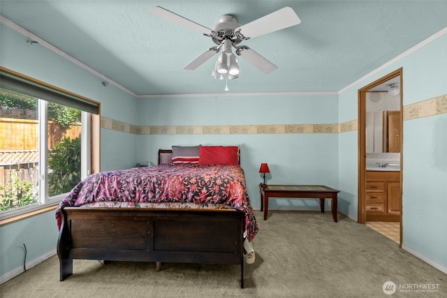carpeted bedroom featuring ornamental molding, a sink, ceiling fan, and ensuite bath