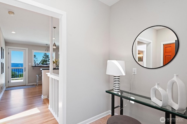 corridor featuring baseboards, wood finished floors, and recessed lighting