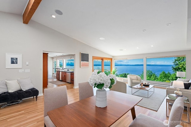 dining room featuring light wood-style flooring, healthy amount of natural light, recessed lighting, and a water view