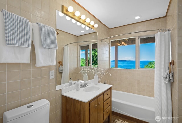 full bathroom with tile walls, shower / tub combo with curtain, toilet, and vanity