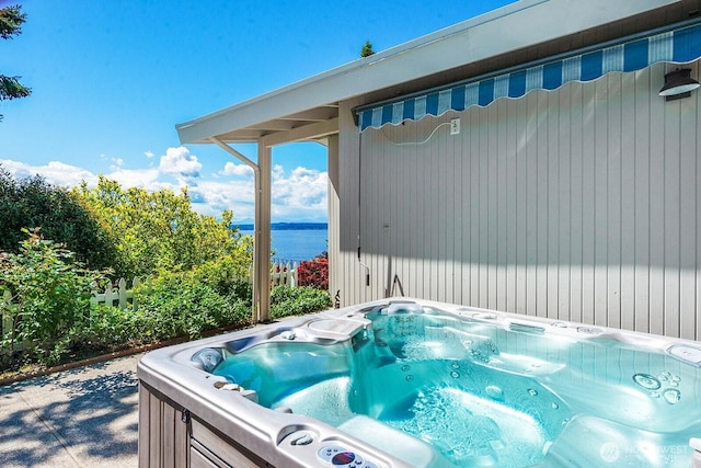 view of pool featuring a hot tub and a water view