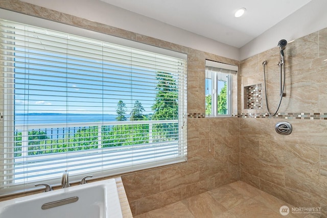 bathroom featuring a soaking tub and tiled shower
