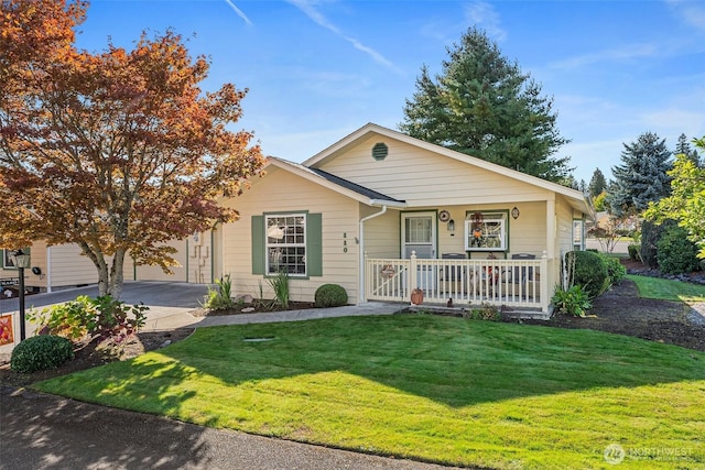 view of front facade with an attached garage, driveway, covered porch, and a front yard
