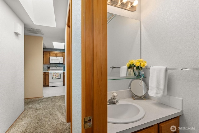 bathroom featuring vanity, a textured wall, and visible vents