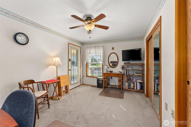 carpeted office featuring a textured ceiling and ceiling fan